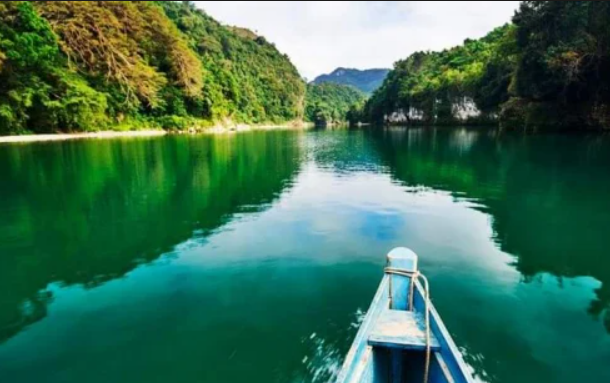 The Pinacanauan River is a pristine, deep-emerald waterway flanked by monumental limestone karst formations and dense, old-growth rainforests.